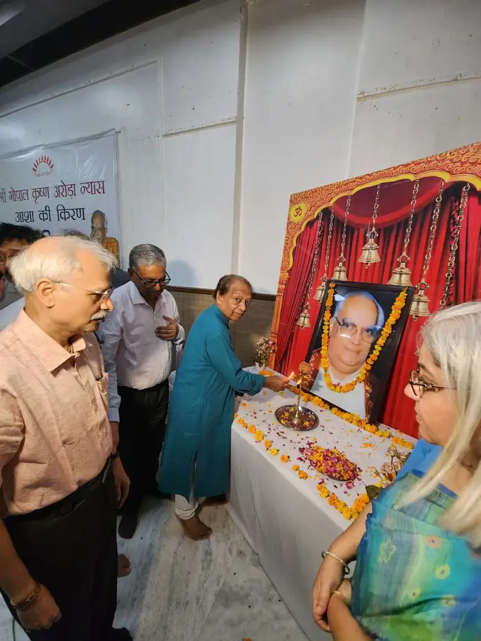 Members of the Nyaas lighting a lamp before a portrait of Shri Gopal Krishna Arora